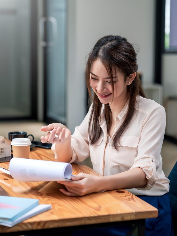 happy-young-asian-businesswoman-to-work-holding-documents-at-the-office-.jpg